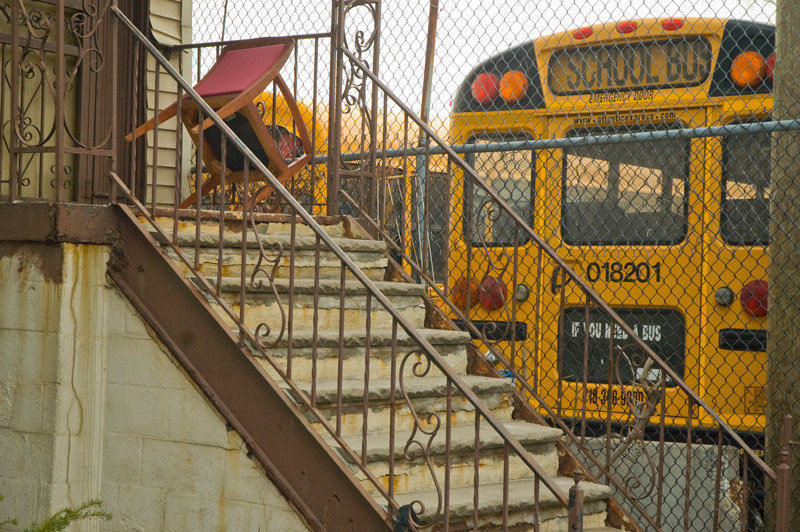 A school bus parked next to a home's stoop.