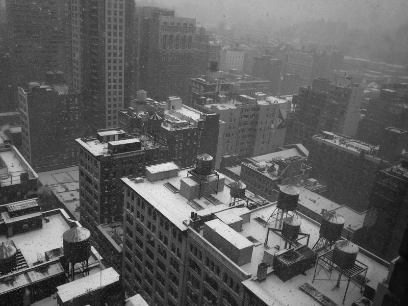 City buildings with snow on the roofs.