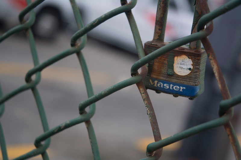 A padlock on chain link fence.