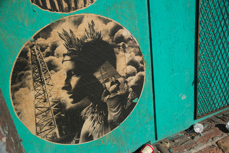 A wheatpaste street art, woman with crown like Statue of Liberty.