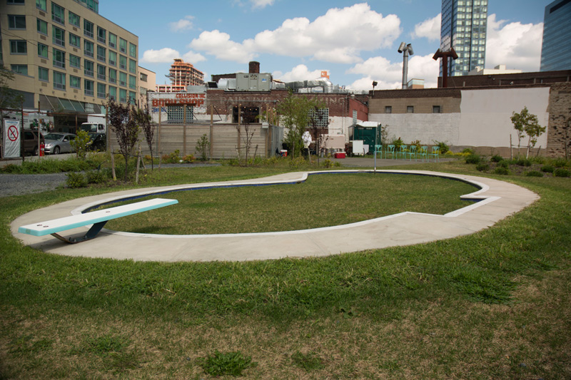 A sculpture of a pool, filled to the brim with grass.