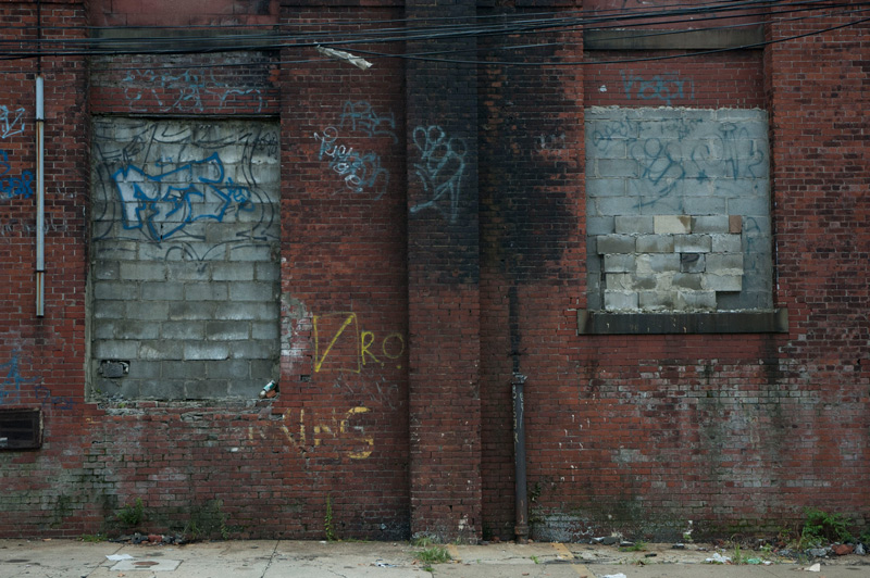 A beat-up brick wall with graffiti