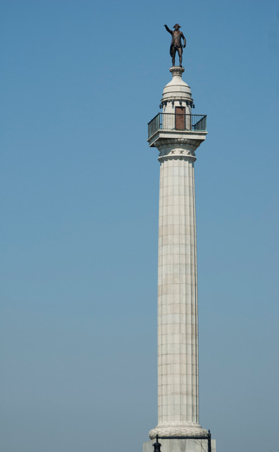 A bronze statue of George Washington at the top of a tall column