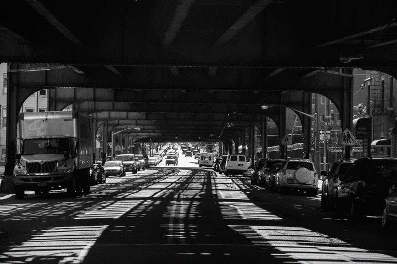 Shadows on a street from an elevated train track