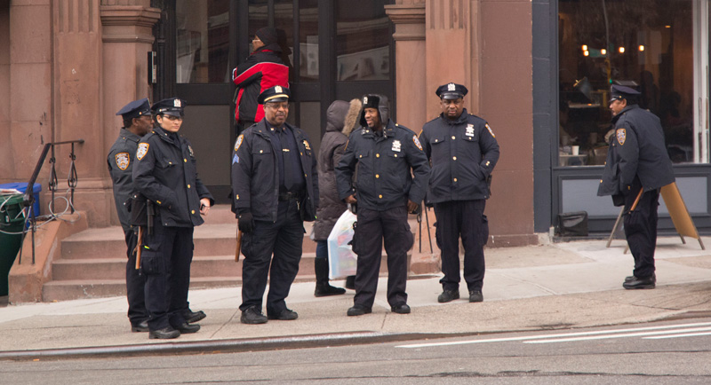 Six uniformed police officers at a corner in Brooklyn.