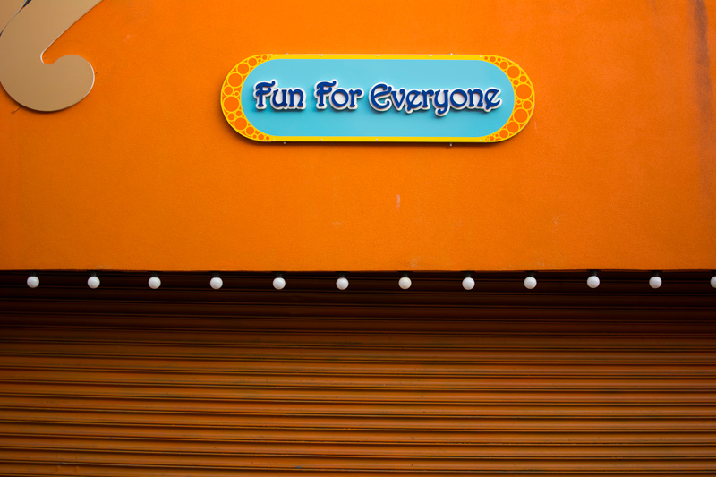 A colorful sign in an amusement park promises fun for everyone.