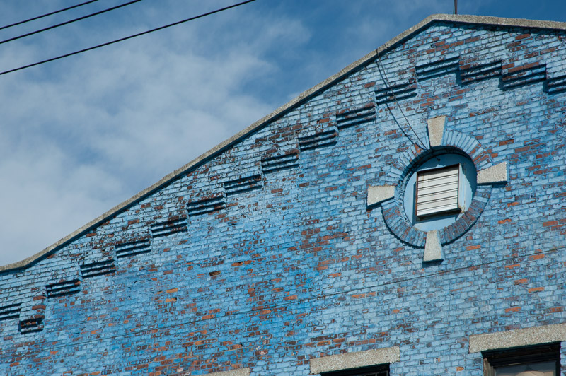 A brck building, with peeling blue paint.