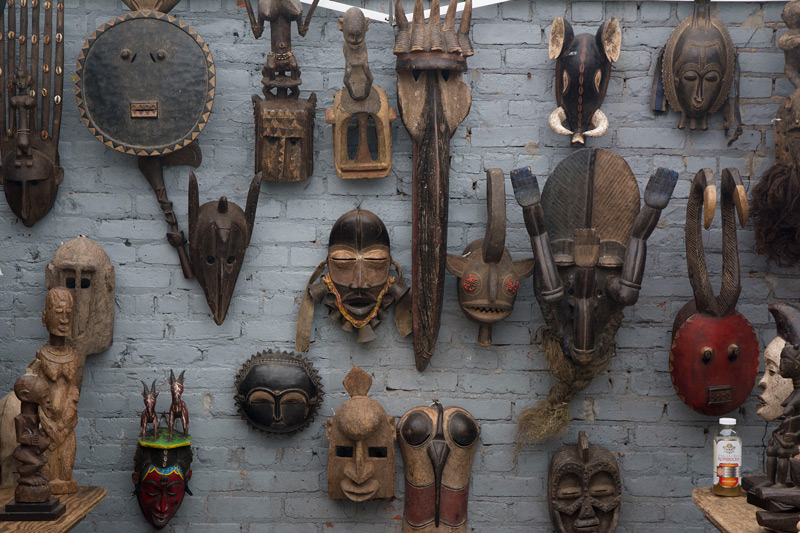 African masks on a wall, for sale at a flea market.