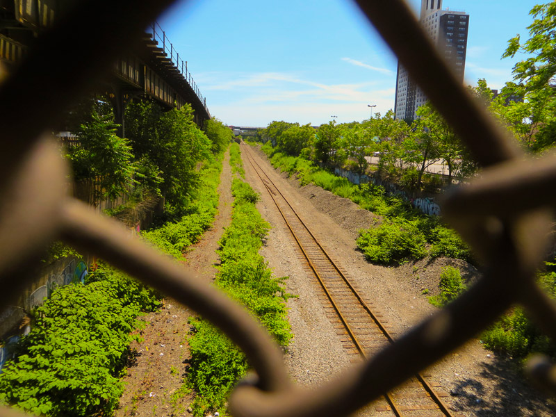 Train tracks, seen through chain link fence.