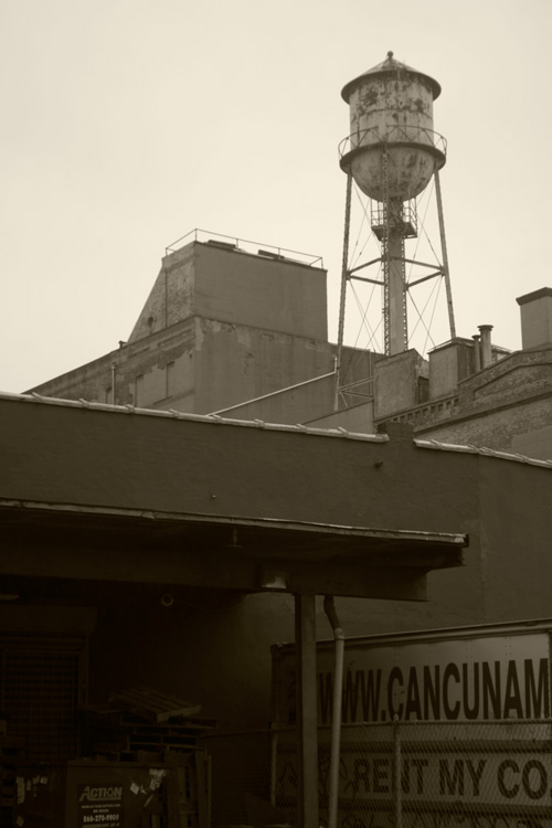A water tank on top of a warehouse.