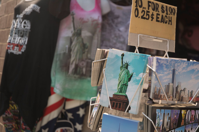 Postcards in a souvenir store, one with the Statue of Liberty.