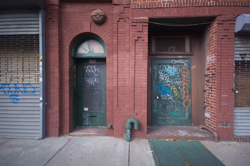 Two doors into a pair of brick buildings.