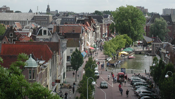 Picture shows a
row of buildings, facing a canal and cafes.