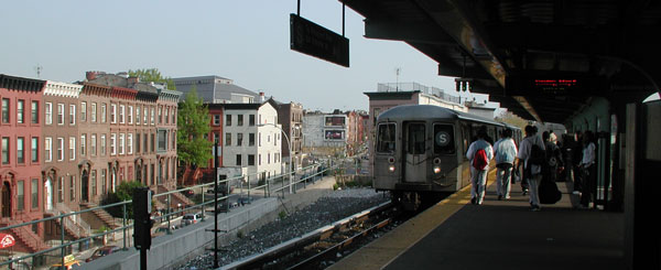 Picture shows a
train pulling into an elevated subway platform.