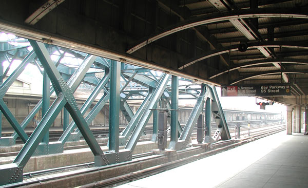 An elevated
subway platform, with bright sunlight on the girders.