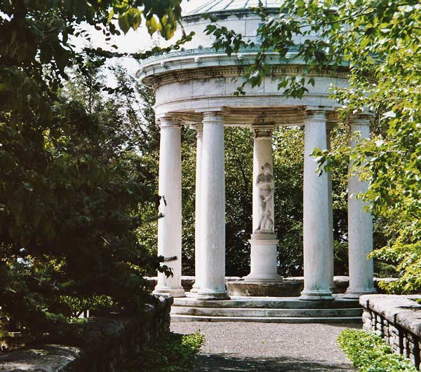 A rotunda, down a walk, has a statue inside.