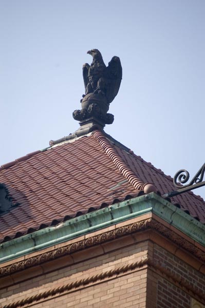 A statues of an eagle sits on a rooftop.